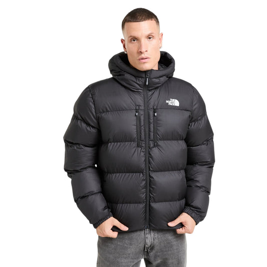 Man wearing a black puffer jacket with 'The North Face' logo on a white background