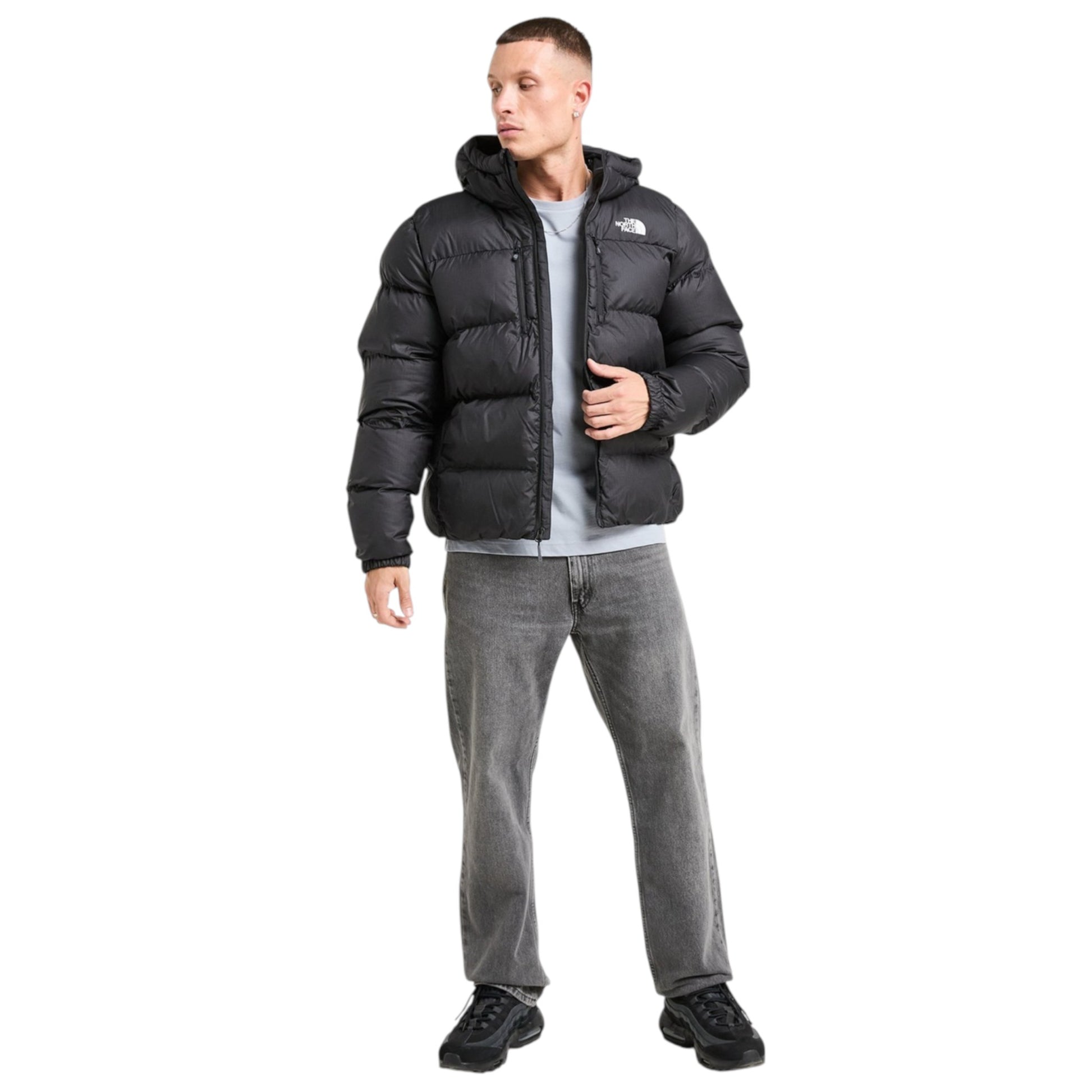 Man wearing a black puffer jacket and gray pants on a white background
