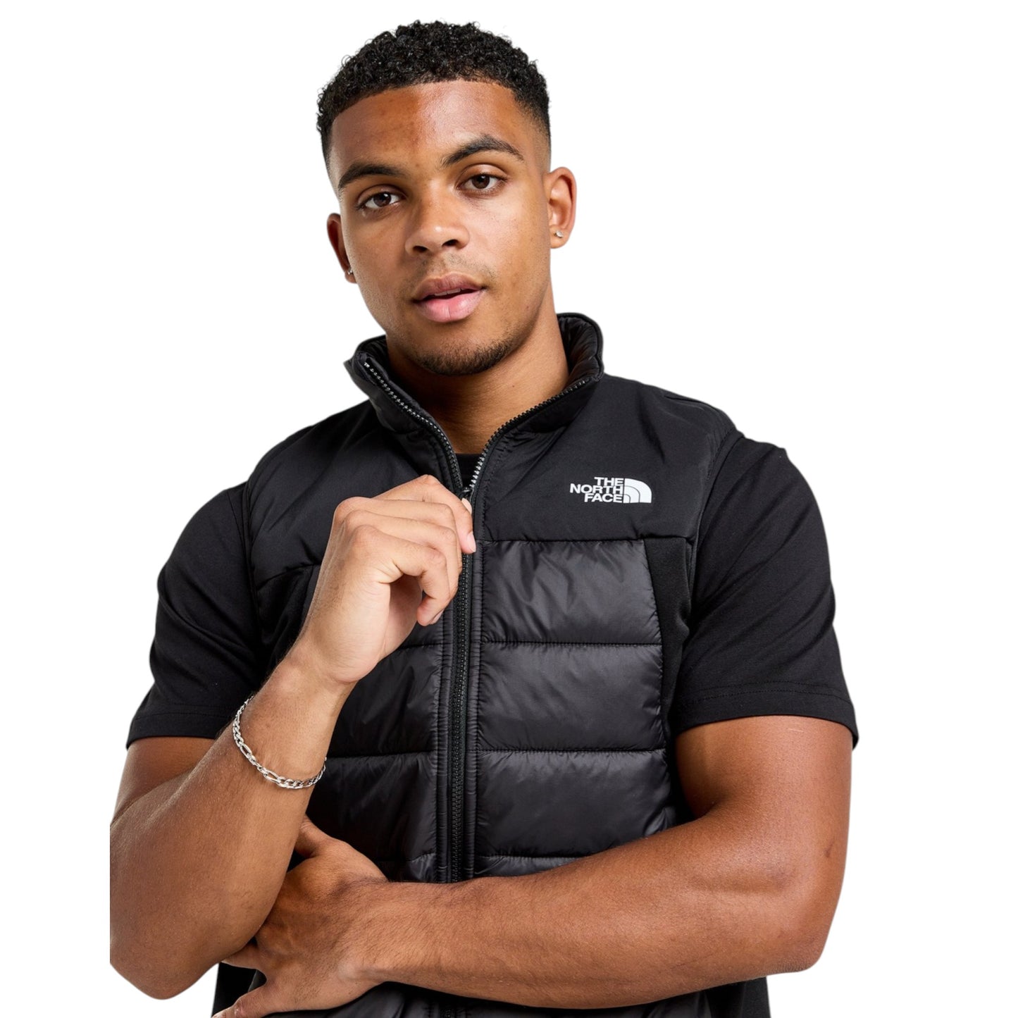 Man wearing a black puffer vest with The North Face logo on a white background