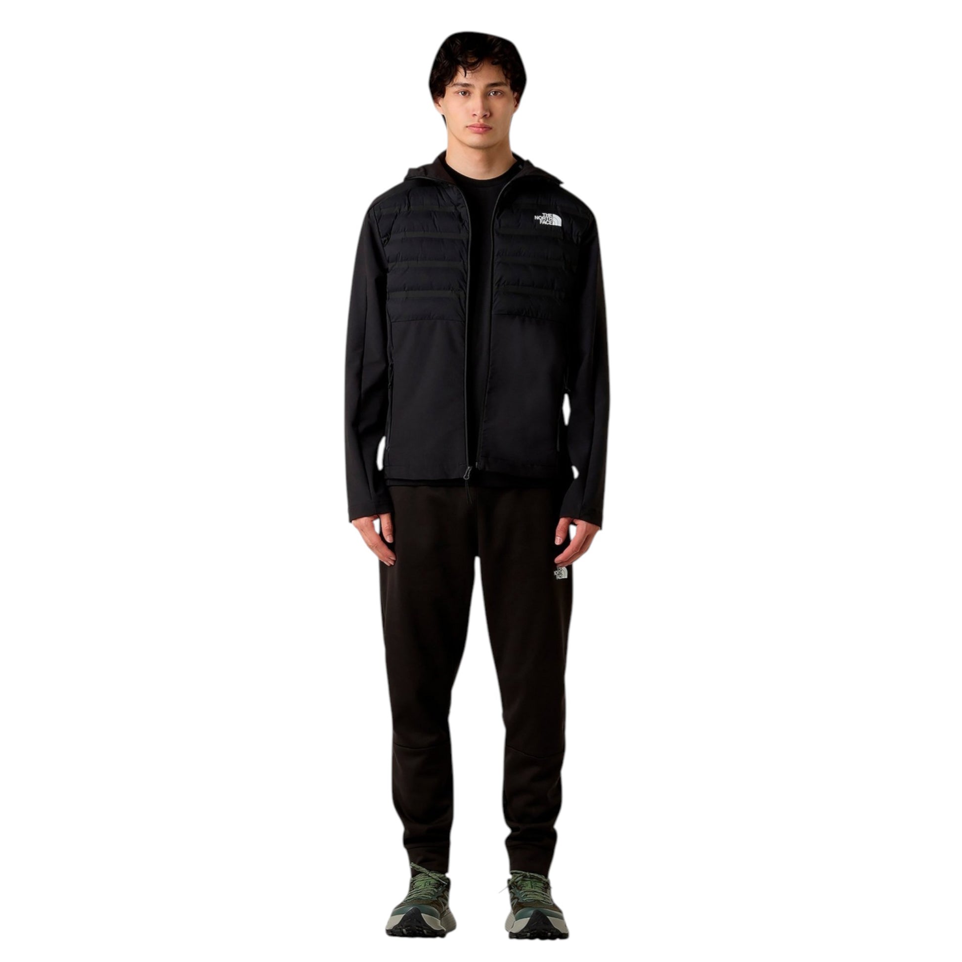 Person wearing a black jacket and pants with a logo on a white background