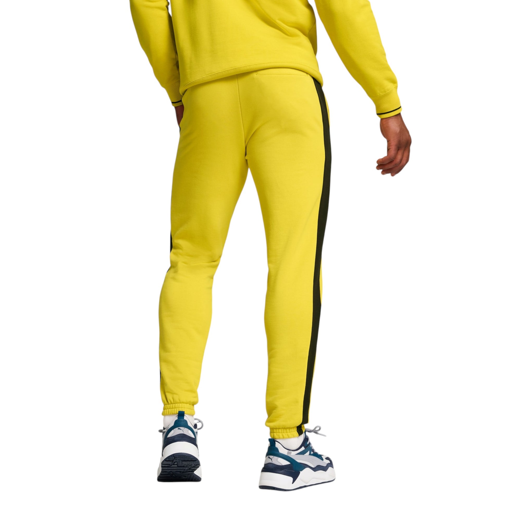 Yellow tracksuit with black side stripe worn by a person on a white background