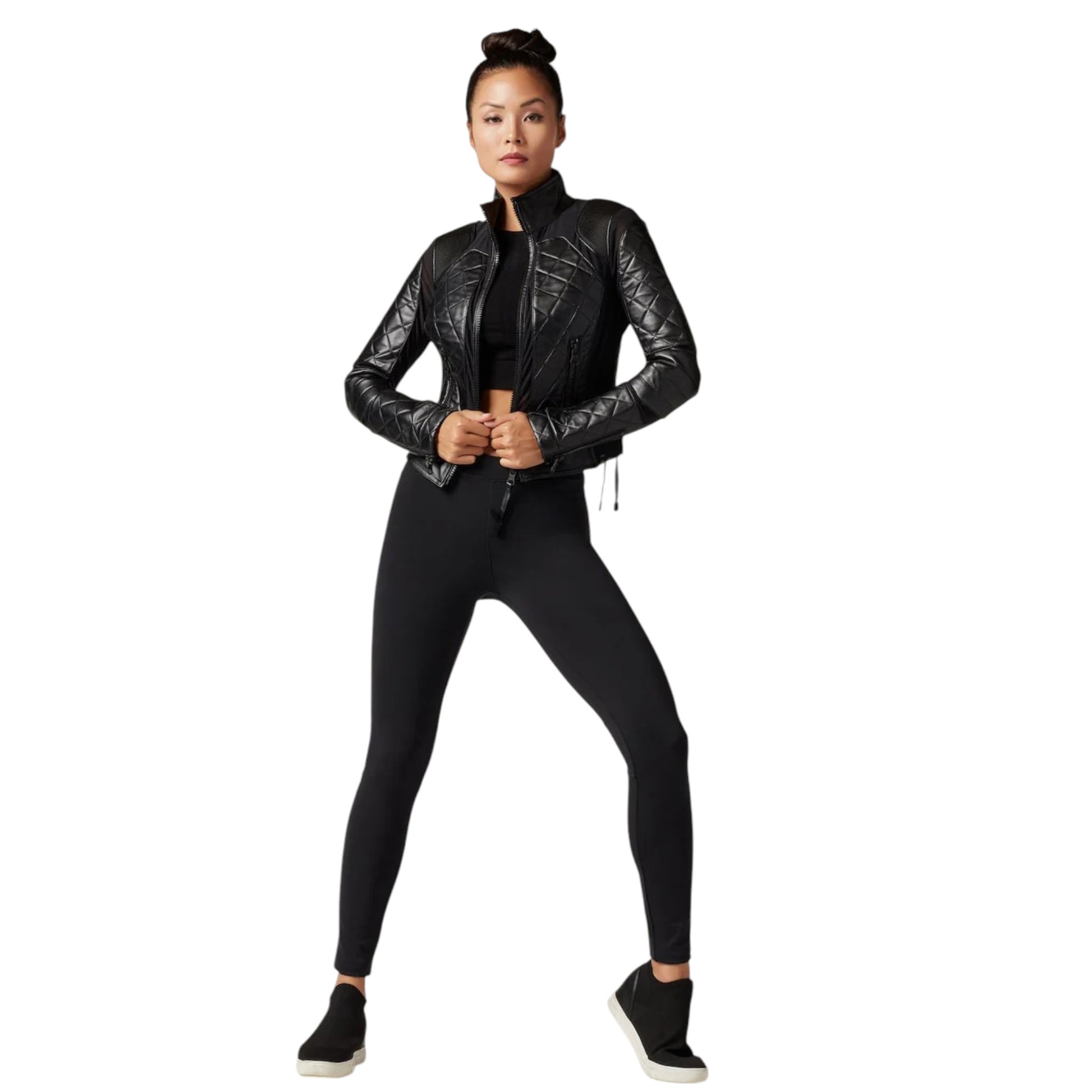 Person wearing a black leather jacket and leggings on a white background